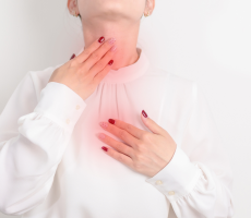 Žena s nelagodom u grlu i prsima uzrokovanom laringofaringealnim refluksom.